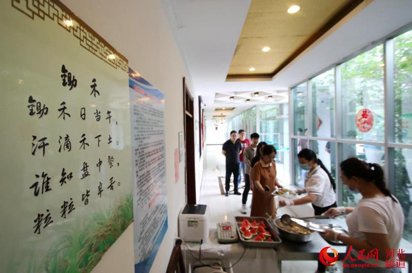 8月12日，在河北省邯鄲市永年區供電公司職工餐廳，職工正在“誰知盤中餐 粒粒皆辛苦”宣傳畫前取餐。 胡高雷 攝