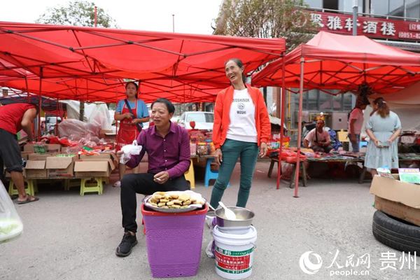 余進芬（右一）在集市賣苞谷粑。