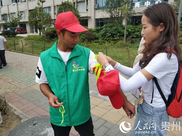 吳敏幫助街道志願者佩戴綠絲帶