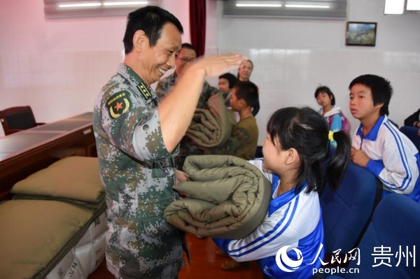 黎平縣人民武裝部政委李唐林在黎平特校捐贈棉被現場。李浩 攝