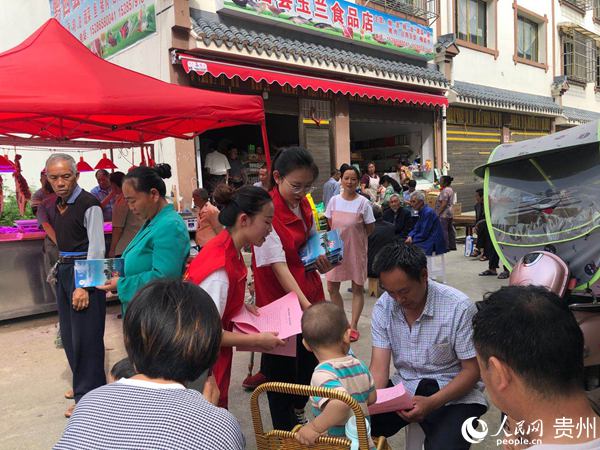 邱佳與同事一起向易搬群眾發放消防安全宣傳單。