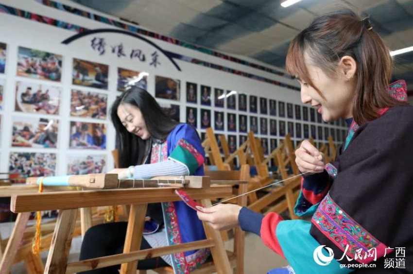 兩名繡娘在三江侗族自治縣古宜鎮南站社區一家繡坊內交流織錦技藝。龔普康攝