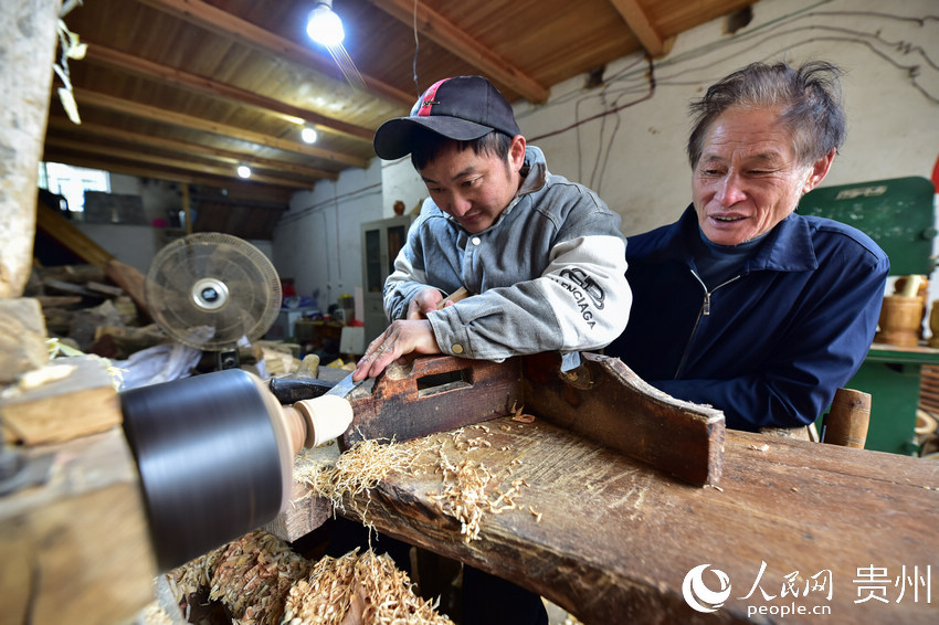 貴州省丹寨縣龍泉鎮，吳明章（右）在好友的木藝加工作坊參觀。