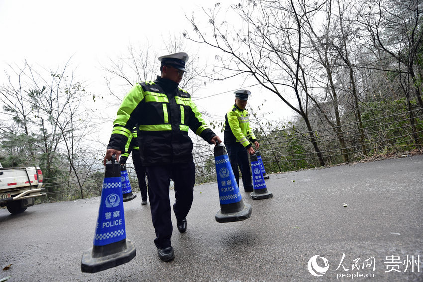 12月15日，民警在貴州省丹寨縣丹排公路擺放警示錐形桶，進行交通管制。
