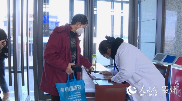 工作人員正在為不會使用智能手機的老年人登記身份信息。
