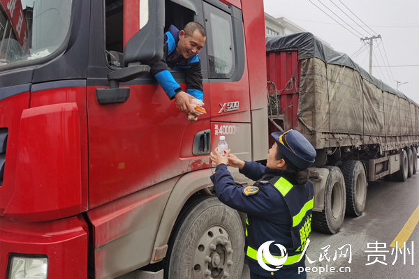 廖貴鳳給道路受阻受困駕駛員送食物。郭雨田 攝
