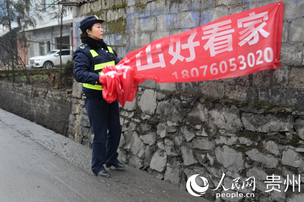 廖貴鳳清理非公路宣傳橫幅。郭雨田 攝