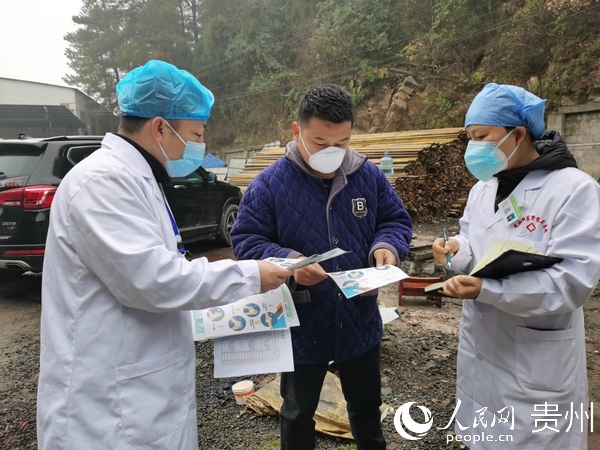 疫情期间，罗城给居民发放宣传册（左一为罗城）。观山湖区融媒体中心供图