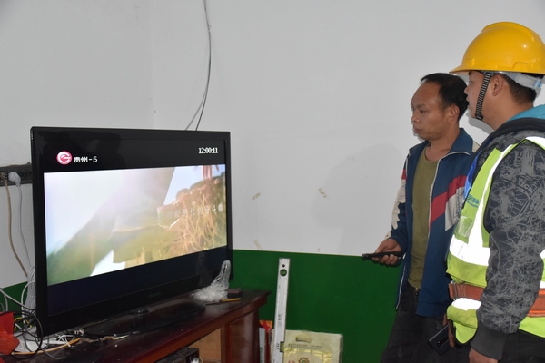 移動建維人員正在給村民陳天龍講解網絡電視的使用方法。