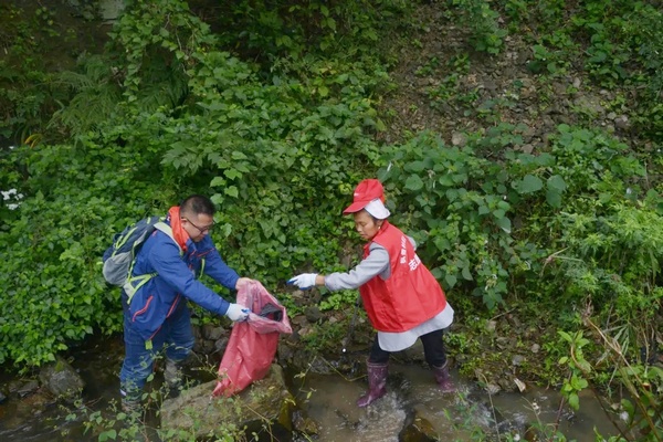 “全國最美河湖衛士”楊再春（左）和村民護水隊員一起巡河清污。鄒莎莎攝