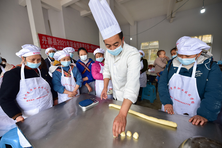 4月8日，在貴州省丹寨縣金泉街道易地扶貧搬遷安置區，搬遷群眾在技能培訓人員的指導下學習糕點制作。