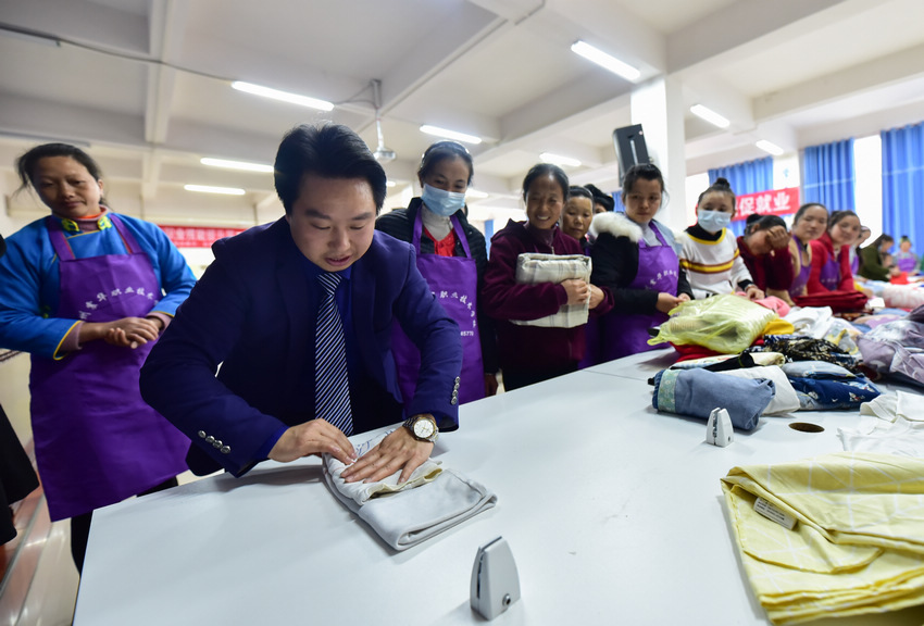 4月8日，在貴州省丹寨縣金泉街道易地扶貧搬遷安置區，搬遷群眾在技能培訓人員的指導下學習衣物折疊。
