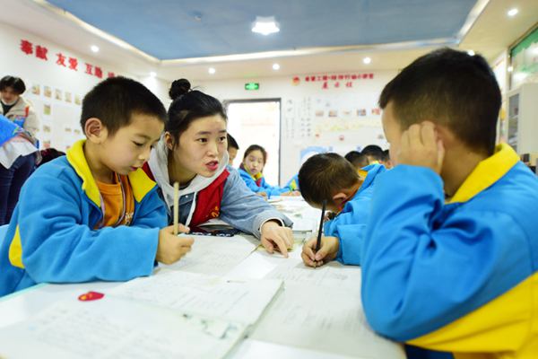 岑巩县大坪同心社区，志愿者正在“四点半学校”为学生耐心地辅导功课。唐鹏 摄
