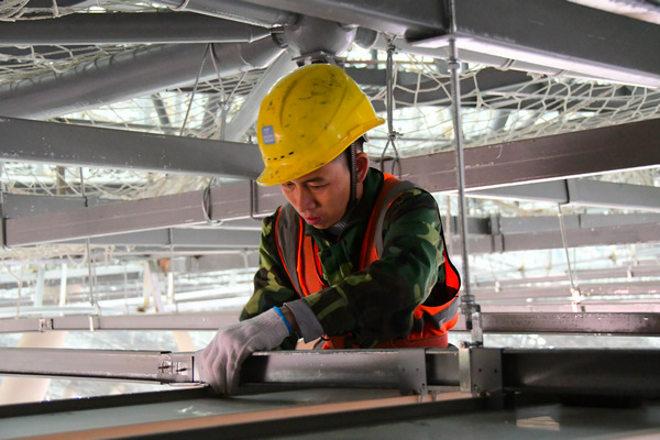 中建三局貴陽龍洞堡國際機場T3航站樓施工總承包項目工人謝德明正在拼裝吊頂材料。王雪飛攝