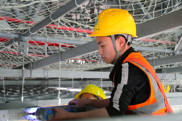 中建三局貴陽龍洞堡國際機場T3航站樓施工總承包項目工人鐘瑞振正在拼裝吊頂材料。王雪飛攝