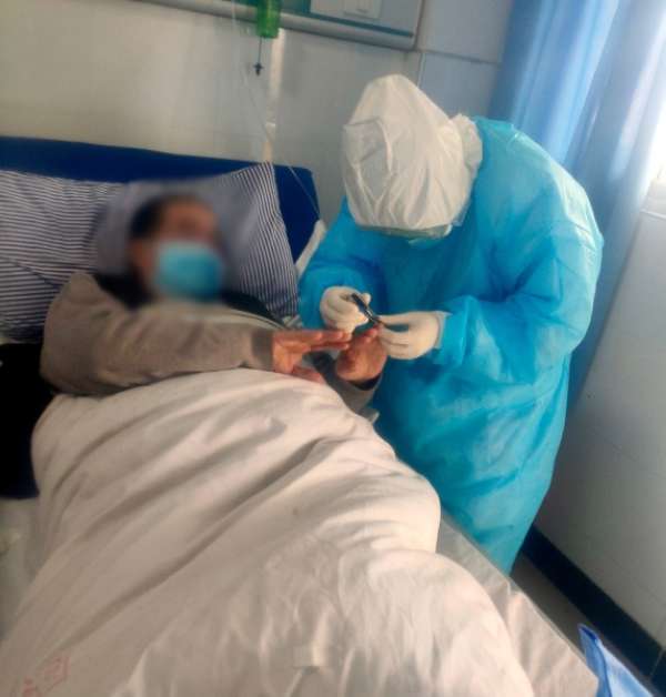 在湖北工作期間，趙青為患者剪指甲。受訪者供圖