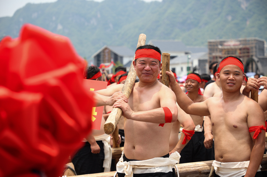 6月9日，在貴州省黔東南苗族侗族自治州施秉縣，參加活動的群眾向觀眾展示抬龍舟的動作。