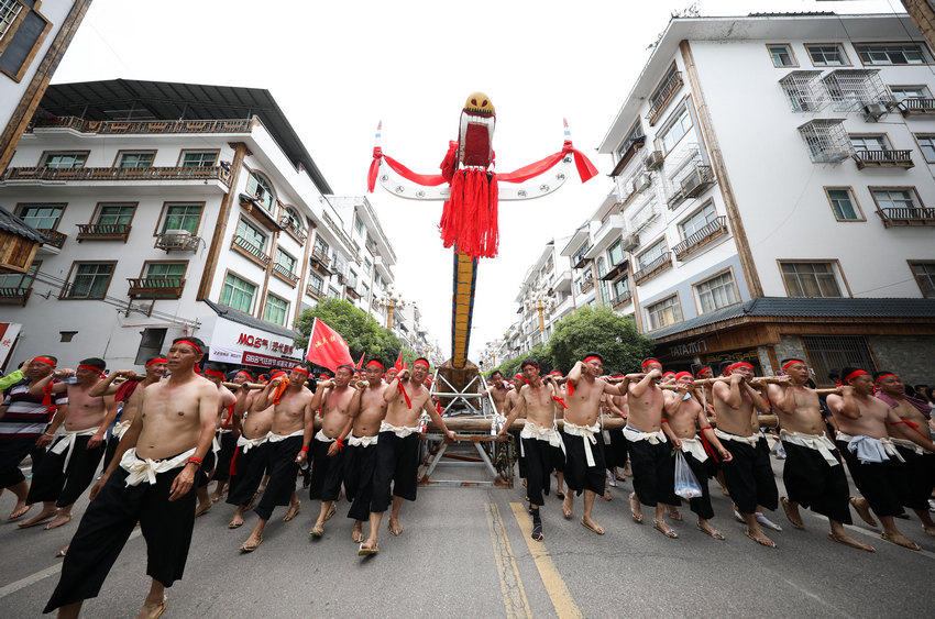 6月9日，在貴州省黔東南苗族侗族自治州施秉縣，群眾抬著木龍舟在縣城街道巡游。