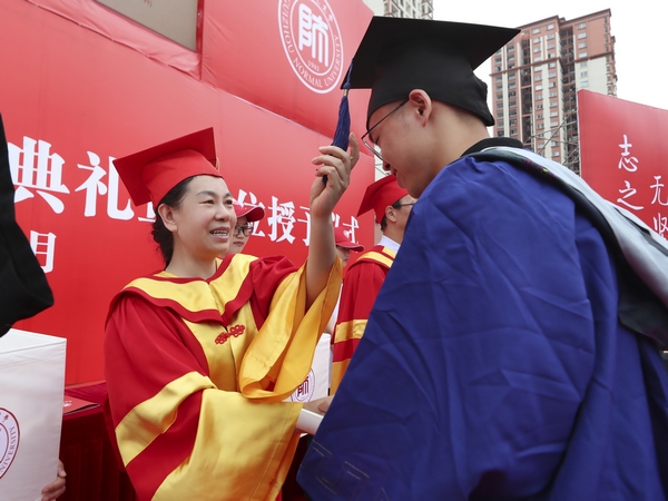 貴師范大學黨委書記韓卉為畢業生撥正學位帽流蘇。