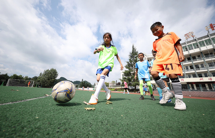 7月11日，在貴州省丹寨縣揚武中學足球場，小球員在練習傳球技術。