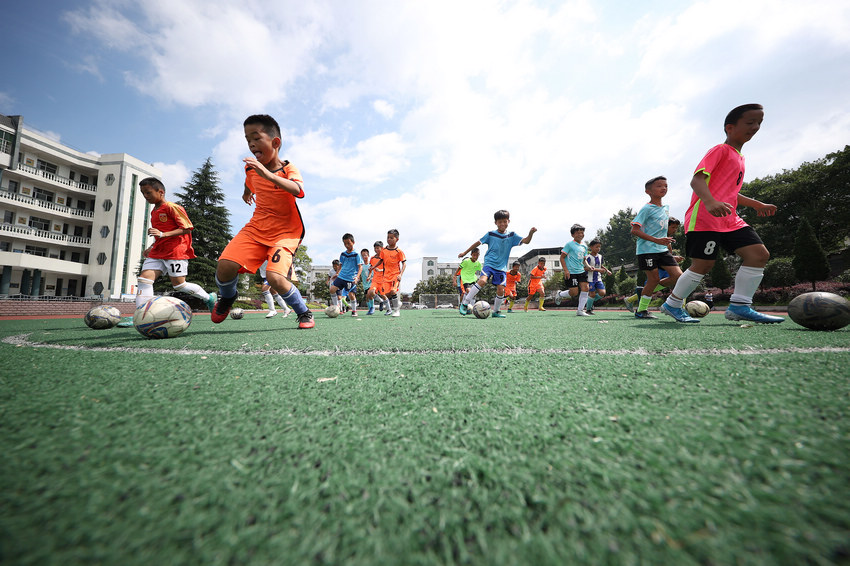 7月11日，在貴州省丹寨縣揚武中學足球場，小球員在練習速度帶球。