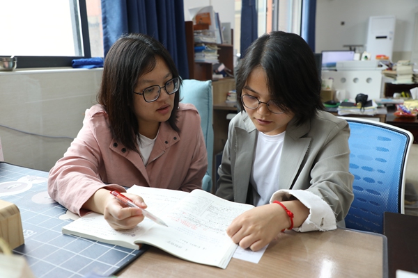 蒋宜芳（左一）与其他老师讨论教学内容。观山湖区融媒体中心供图