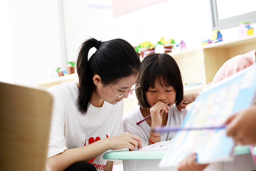 7月28日，來自南昌大學人文學院的大學生志願者給思源社區的孩子輔導作業。