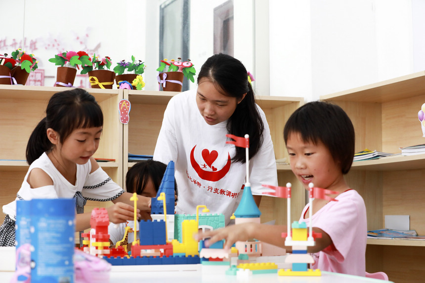 7月28日，來自南昌大學人文學院的大學生志願者和思源社區的孩子在玩游戲。