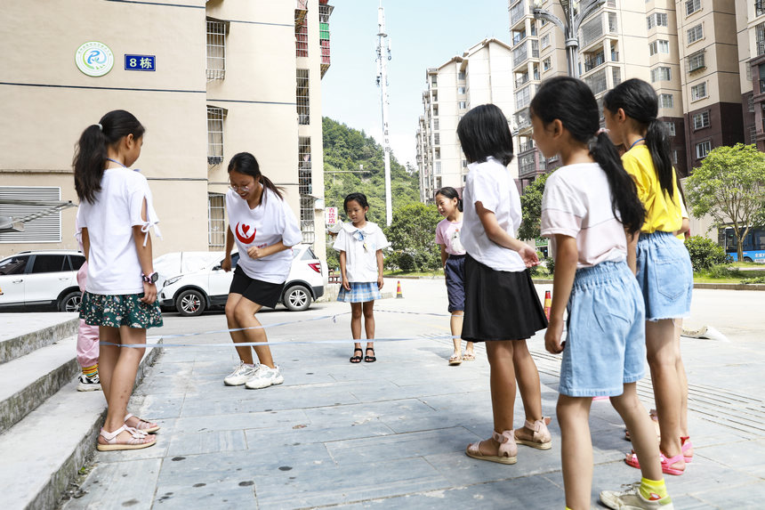 7月28日，來自南昌大學人文學院的大學生志願者和思源社區的孩子玩跳皮筋游戲。