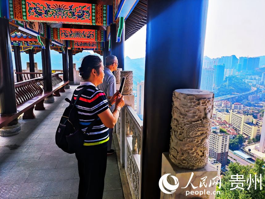 游客在長廊駐足拍照，俯瞰城市景色。人民網 唐杰攝