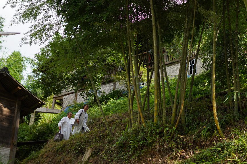 8月17日，在貴州省丹寨縣排調鎮黨早村，肖世軍（右）、潘啟蘭在巡診途中。