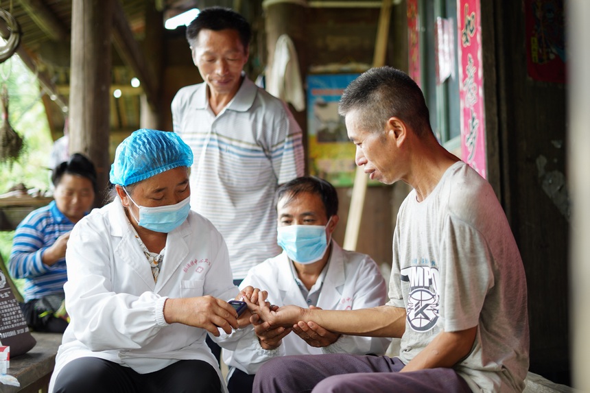8月17日，在貴州省丹寨縣排調鎮黨早村，肖世軍（右二）、潘啟蘭（左前）在為苗族村民測量血糖。