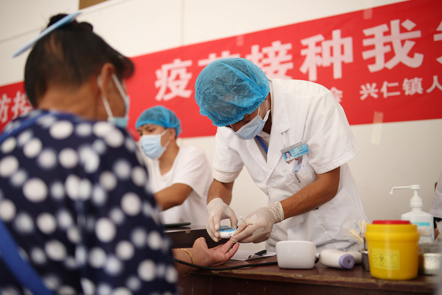 8月21日，在貴州省黔東南苗族侗族自治州丹寨縣興仁鎮翻仰村接種點，醫護人員對村民進行新冠疫苗接種前血糖檢查。