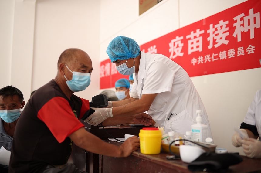 8月21日，在貴州省黔東南苗族侗族自治州丹寨縣興仁鎮翻仰村接種點，醫護人員對村民進行新冠疫苗接種前血壓測量。