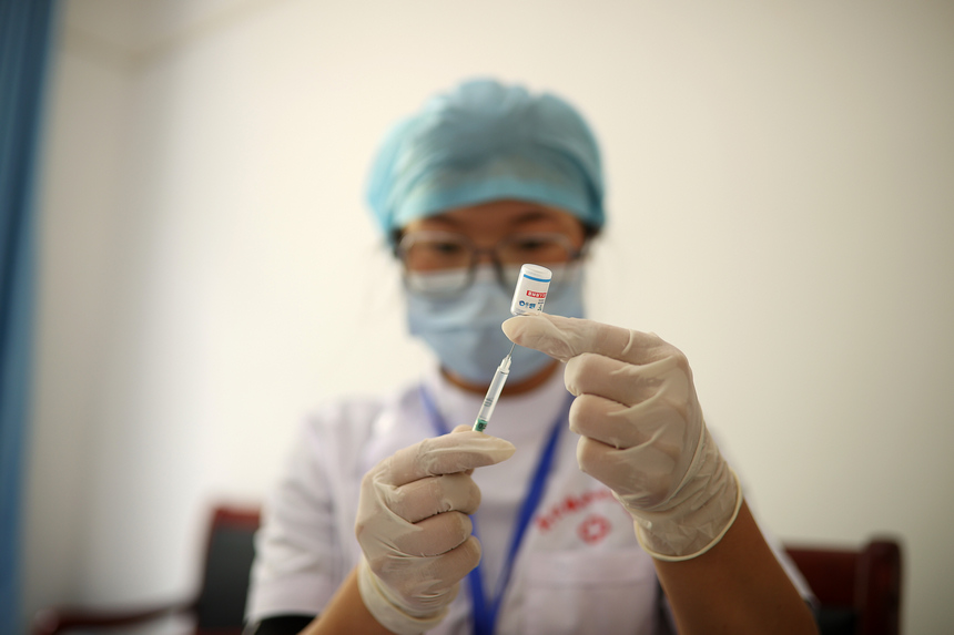 8月21日，在貴州省黔東南苗族侗族自治州丹寨縣興仁鎮翻仰村接種點，疫苗接種人員給村民准備接種疫苗。