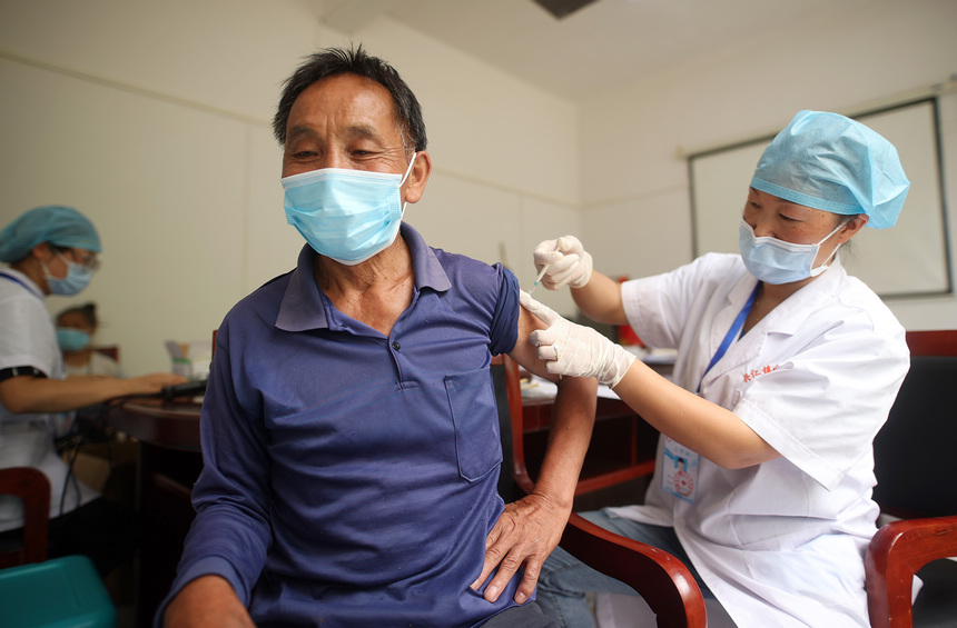 8月21日，在貴州省黔東南苗族侗族自治州丹寨縣興仁鎮翻仰村接種點，疫苗接種人員給村民接種新冠疫苗。