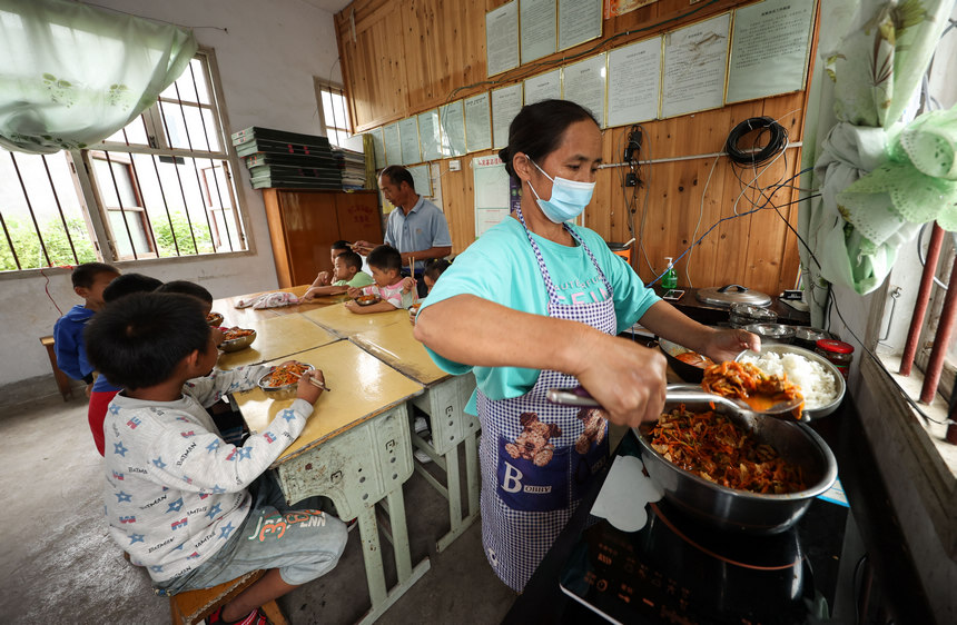 9月8日，在貴州省丹寨縣興仁鎮烏猛村教學點，蒙德新的妻子（右）在給學生准備營養午餐。
