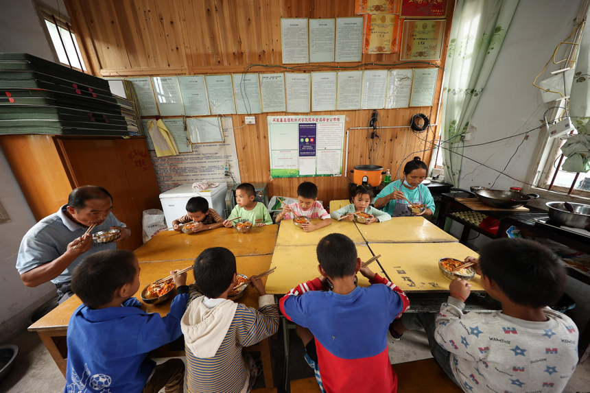 9月8日，在貴州省丹寨縣興仁鎮烏猛村教學點，蒙德新和妻子和小學生一起吃午飯。