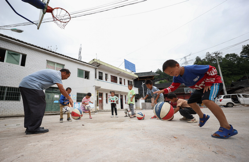 9月8日，在貴州省丹寨縣興仁鎮烏猛村教學點，蒙德新在體育課上教小學生打籃球。