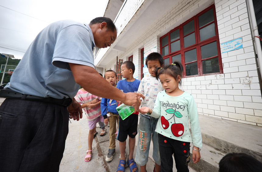 9月8日，在貴州省丹寨縣興仁鎮烏猛村教學點，蒙德新在給學生滴洗手液洗手准備吃午飯。