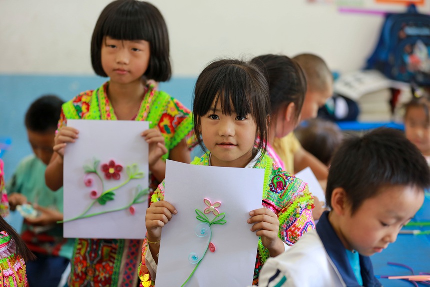 貴州省黔西市素朴鎮屯江教學點苗族復式班一、二年級的孩子展示自己的手工作品。
