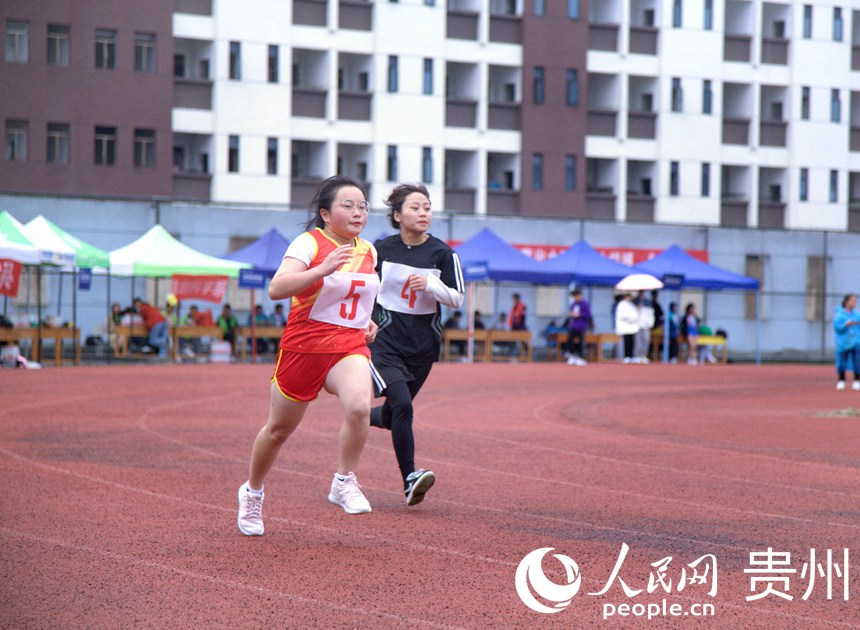 贵阳职业技术学院举行校园运动会，学校学生积极参与跑步比赛。人民网 龙章榆摄