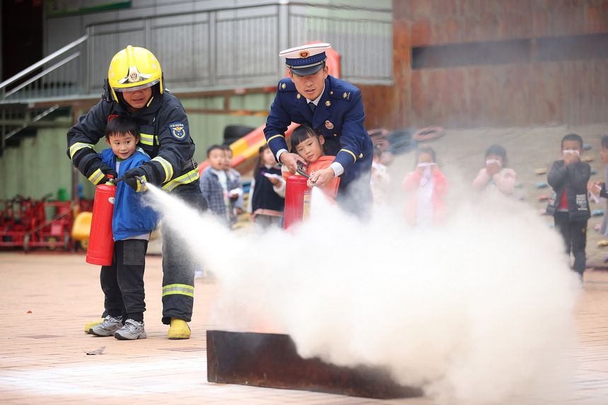11月4日，在貴州省丹寨縣示范幼兒園，消防隊員教孩子們體驗滅火器的使用方式。