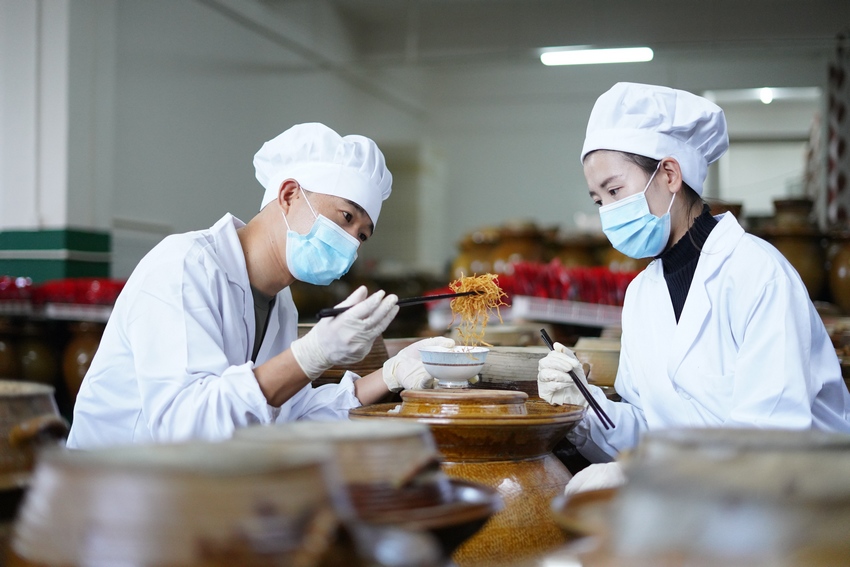 11月5日，在贵州省丹寨县龙泉镇马寨村溪林韭菜根加工厂，陈章林（左）和工人在查看韭菜根腌制情况。