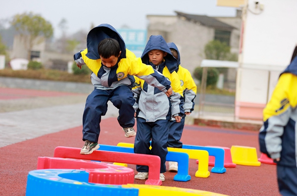 在貴州省黔西市甘棠鎮第二幼兒園孩子們正在做鑽、跨、跳、爬、繞組合做的游戲。