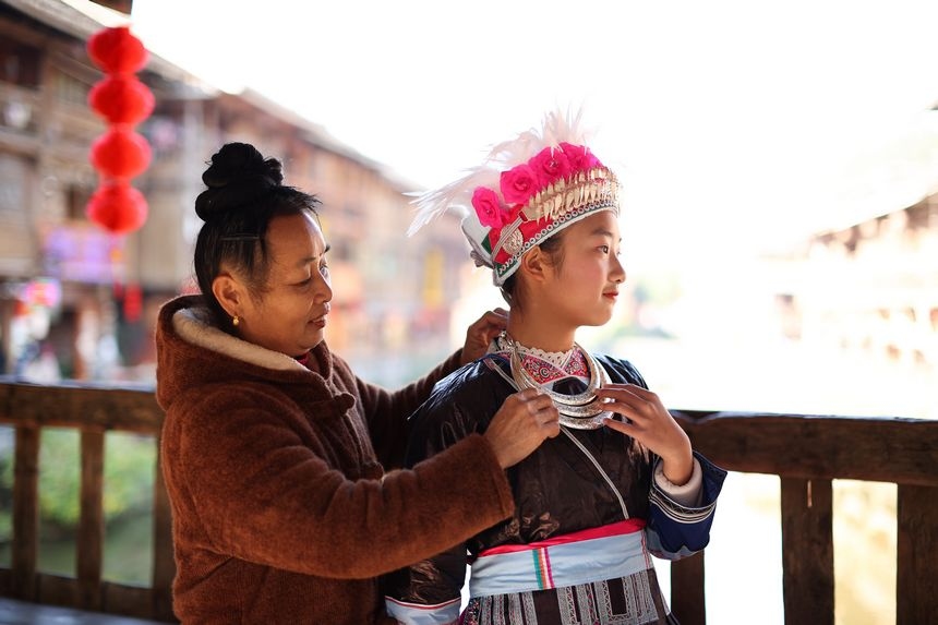 12月5日，一位母親在為侗族小朋友整理侗族節日盛裝。