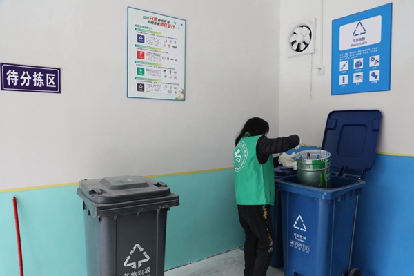 1 綠色生態小屋內，保潔人員對垃圾進行二次分類