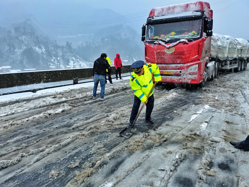 八大队（三穗）交通执法人员在三穗辖区为被困货车除冰开道。