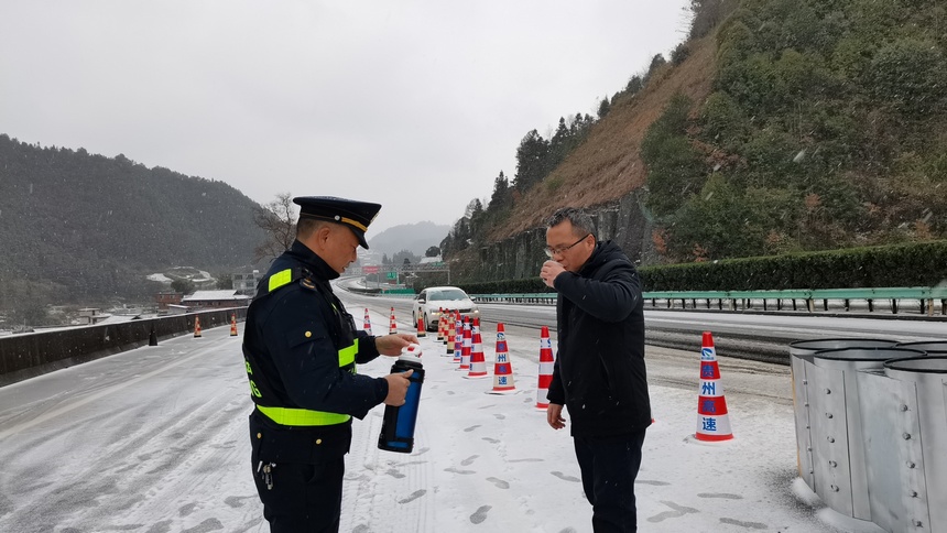 十四大队交通执法人员向被困高速的司乘人员送上温暖的姜茶和食物、护送有急需的人员安全离开高速公路。