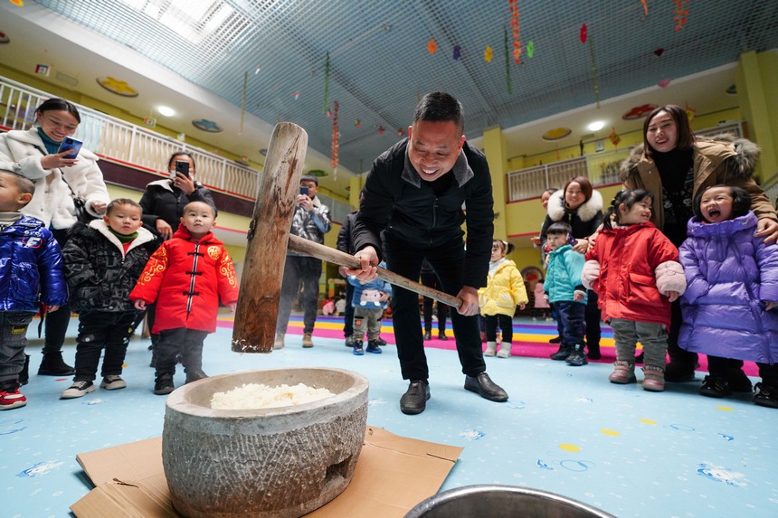12月30日，在貴州省丹寨縣第三幼兒園，小朋友和家長在參加打糍粑活動。